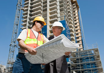 Building developer and contractor discuss progress on a hirise construction project at the job site